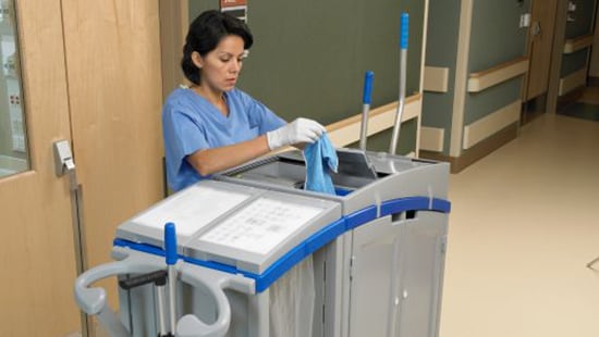 Hospital cleaning staff using an Ecolab hospital cleaning cart for precautions against coronavirus.