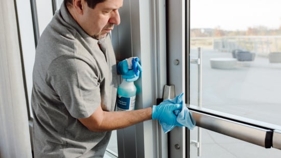 Man wipes door handle with Rapid Multi Surface Disinfectant Cleaner
