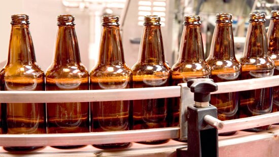Beverage Bottles Running Smoothly on a Lubricated Conveyor Belt 