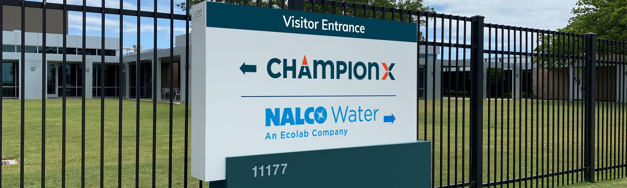  Sign at entrance of Nalco Water office that reads "Visitor Entrance" and directs visitors to proceed left for ChampionX and right for Nalco Water.