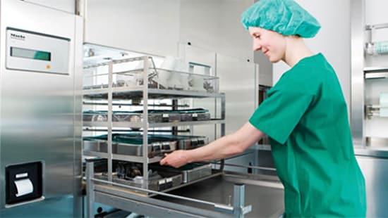 Ecolab instrument reprocessing room with a disinfectant specialist organizing trays in a washing station.