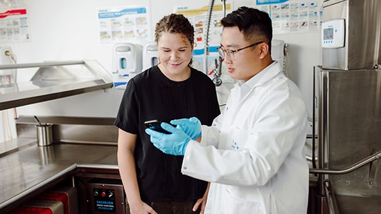 Ecolab expert showing a kitchen manager digital training o a smartphone