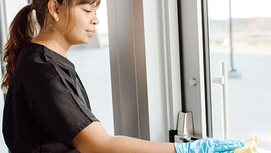 Hotel employee cleaning a door with Ecolab product