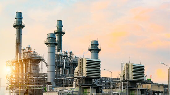 Skyline view of an industrial power plant with several pillars on a sunny day.