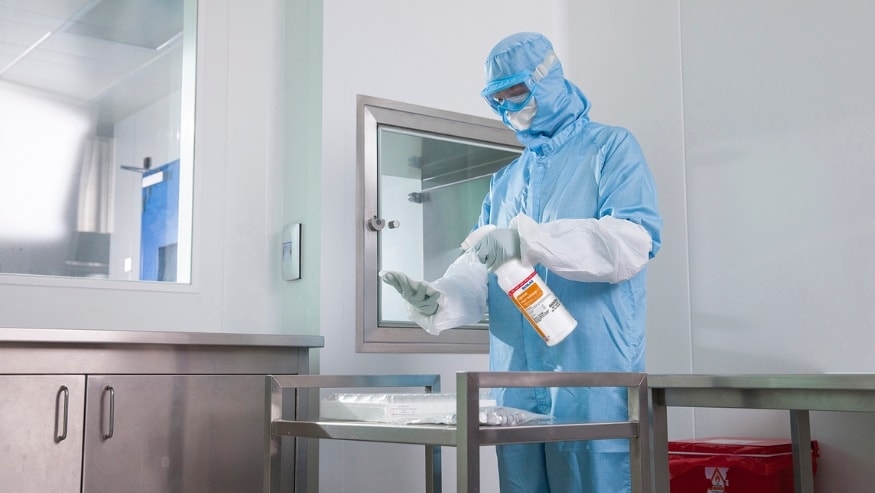 A cleanroom operator spraying KLERCIDE™ RAPID SPORICIDE onto a surface.