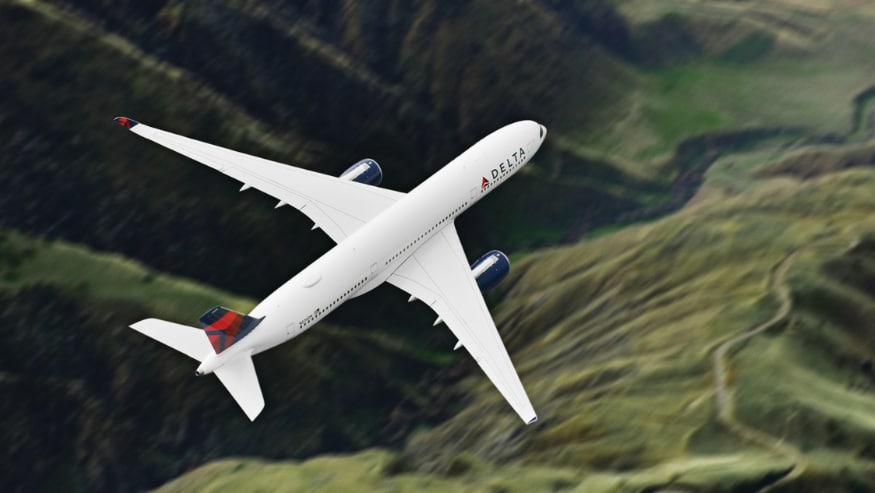 A Delta Airlines aircraft flying over the mountains
