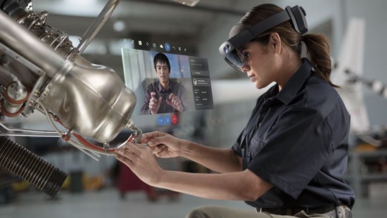 Ecolab energy customer wearing mixed reality headset working on machinery with Ecolab expert on videocall. 