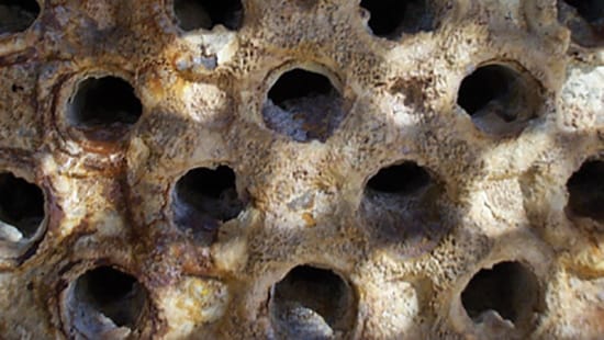 Close up image of metal machinery with rusted, damaged parts.