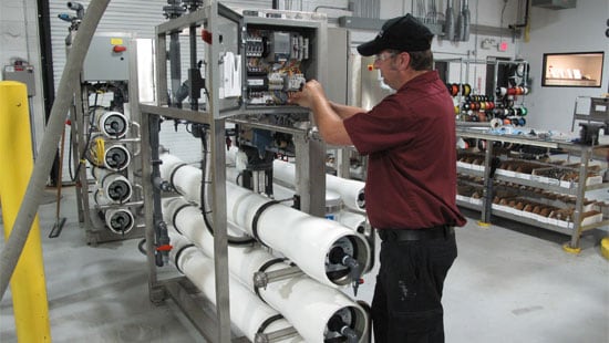 Distributor working on wire panel of large industrial machine.