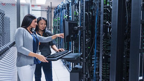 Two women working on solutions at a data center.