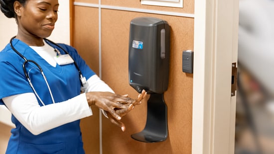 Healthcare worker rubbing Ecolab hand sanitizer between hands.