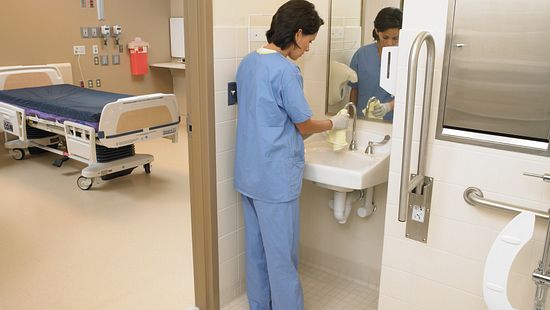 Hospital employee cleaning a sink