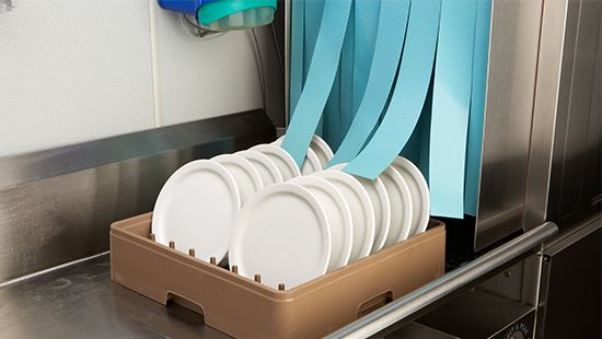 Image of dishes going through a dishmachine.