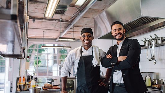Smiling Manager and Chef in Commercial Kitchen