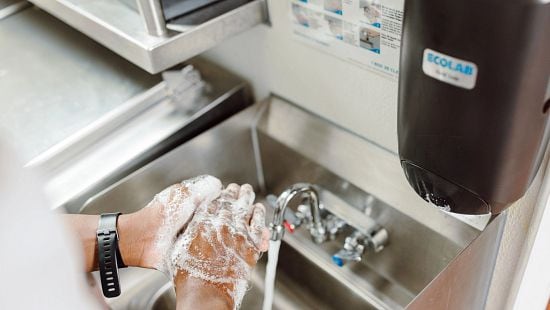 Washing hands in kitchen with Nexa Touchfree dispenser