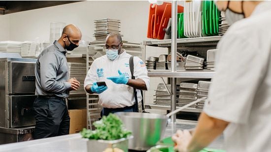 Food Safety Expert Talking to a Front of House Employee inside a Restaurant. 