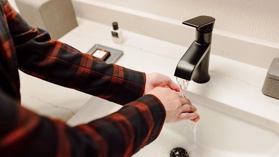 Close up washing hands in bathroom sink