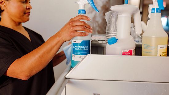Rapid Multi Surface Disinfectant Cleaner (RMSDS) spray bottle in cart with housekeeper