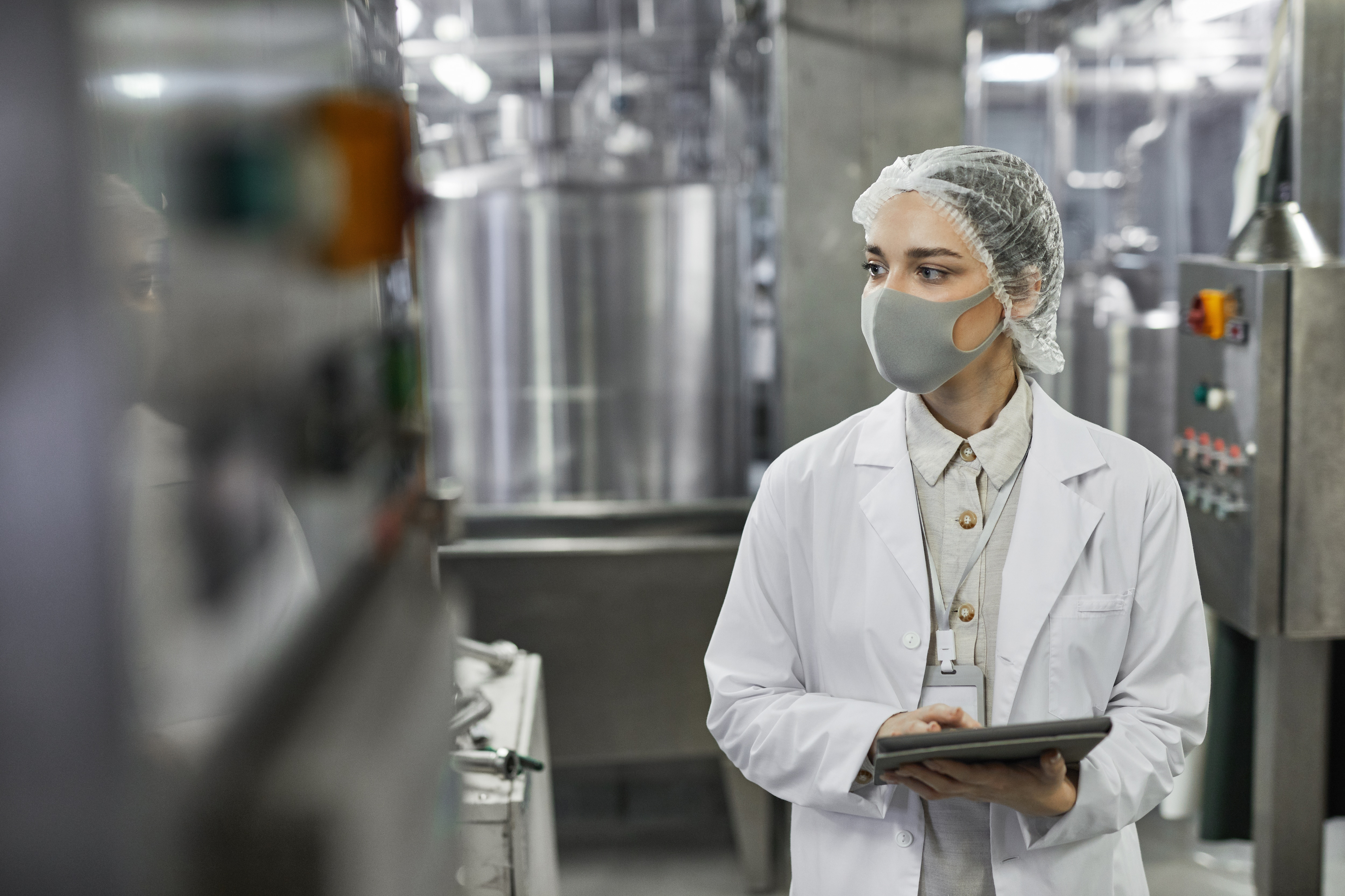 Employee in processing plant inspecting equipment.