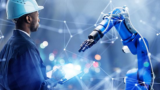 Expert in hardhat working in digital manufacturing building a robot