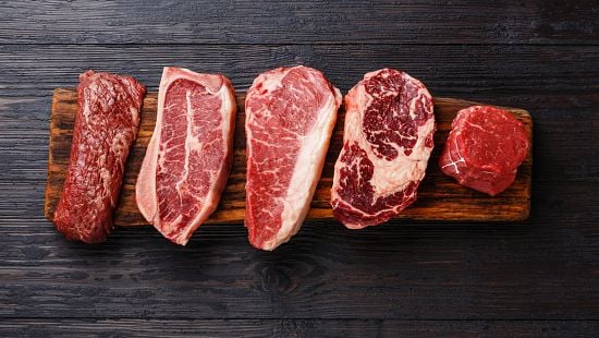 Variety of Raw Black Angus Prime meat steaks Machete, Blade on bone, Striploin, Rib eye, Tenderloin fillet mignon on wooden board