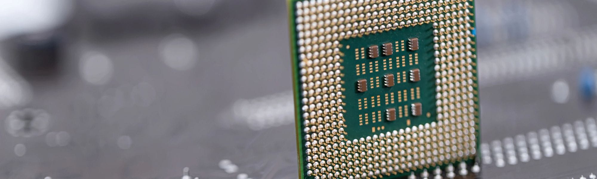 Semiconductor manufacturing stock photo, An old computer processor stands on background of motherboard