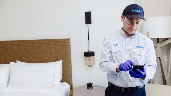 Ecolab associate inspecting hotel room for pests.